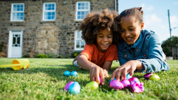 Family outdoors having an Easter egg hunt.