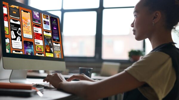 Marketer looking at Halloween email marketing designs on computer