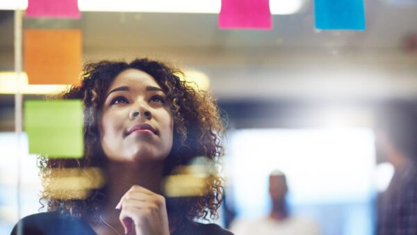 woman marketer looking at post-its, balancing creativity and data-driven marketing