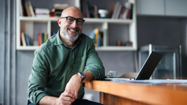 Professional Man Sitting at Desk in Modern Office Space stock photo