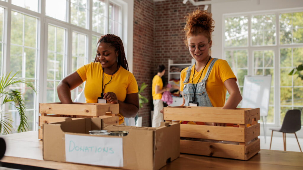 Two charity marketers packing a donation box