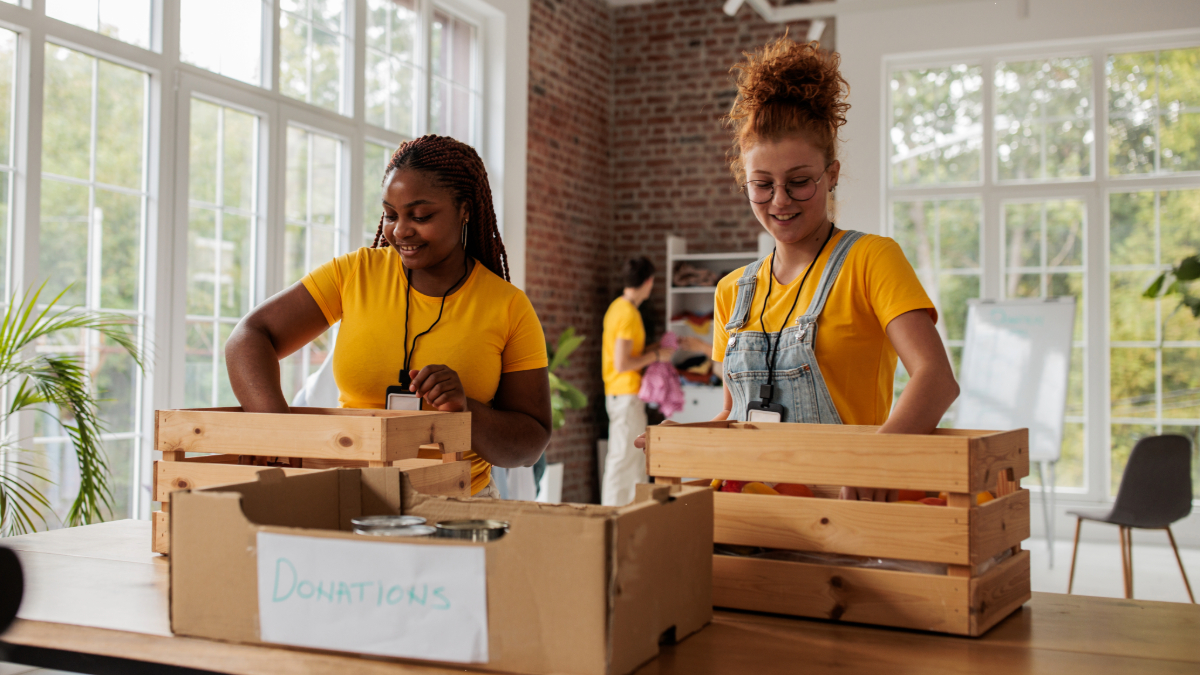 Two charity marketers packing a donation box