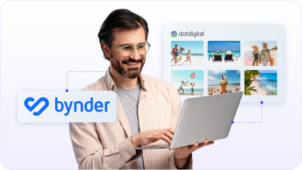 Man with glasses and a beard smiling holding laptop happy about Dotdigital integration with Bynder